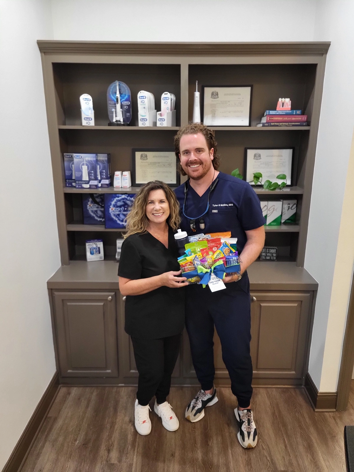 Dentist and team member holding a gift basket at Smart Dental Care, Prairieville, LA