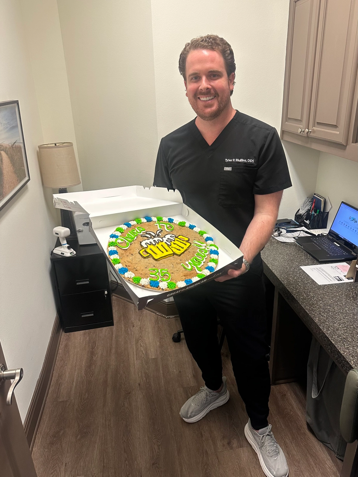 A man holding a decorated cookie cake