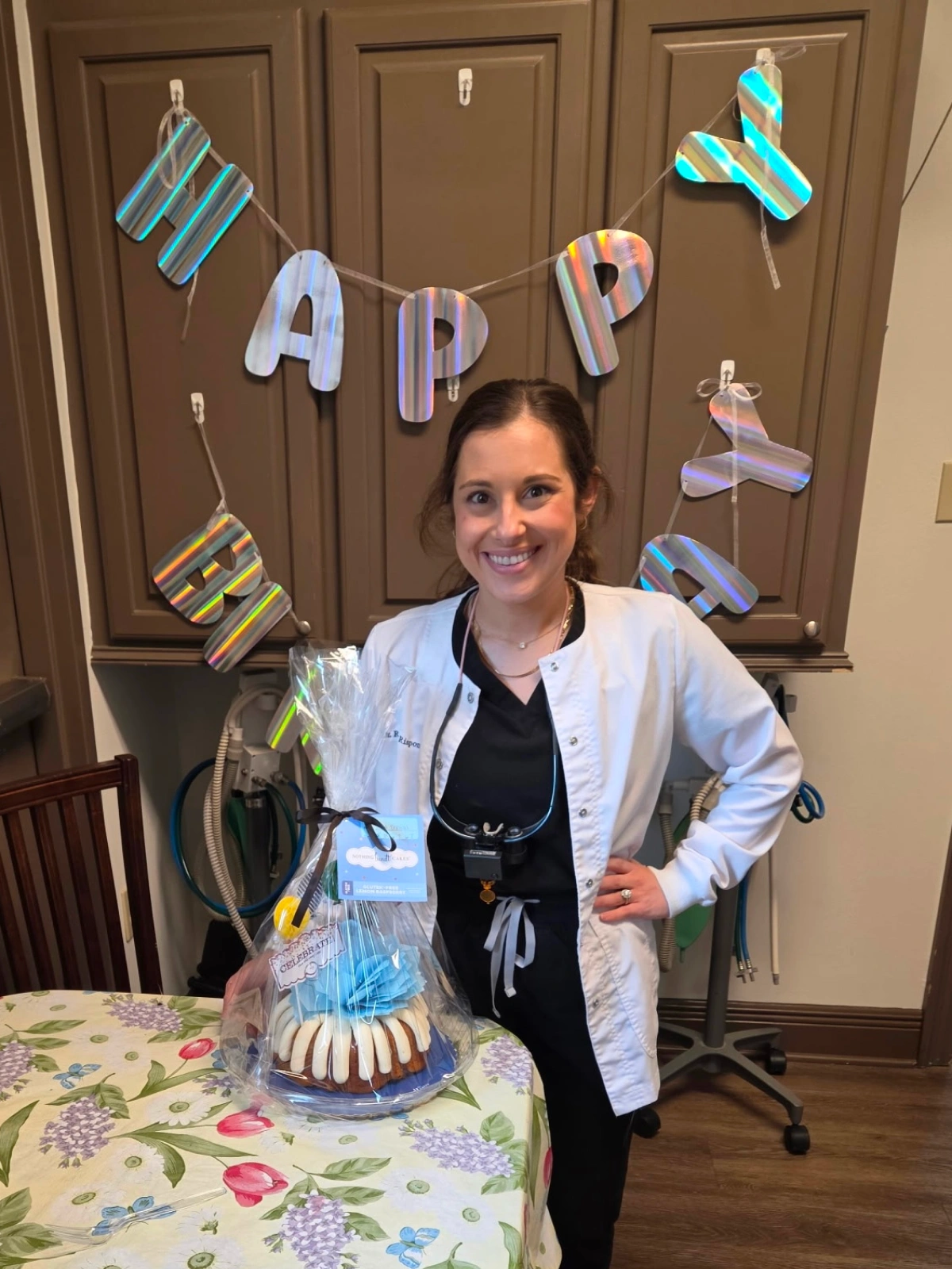 A female doctor standing beside a table decorated with balloons
