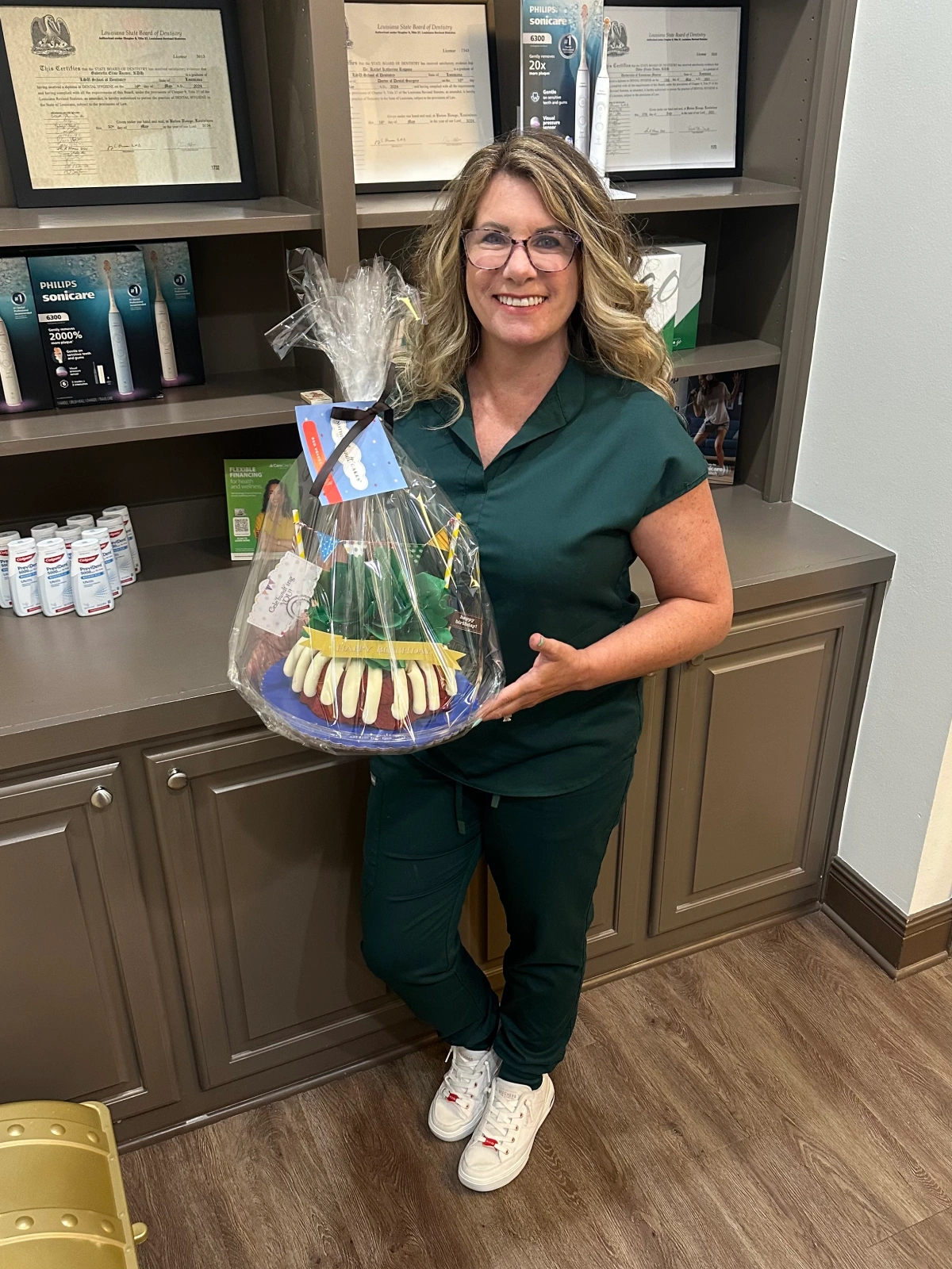 A female healthcare provider holding a gift basket in an office