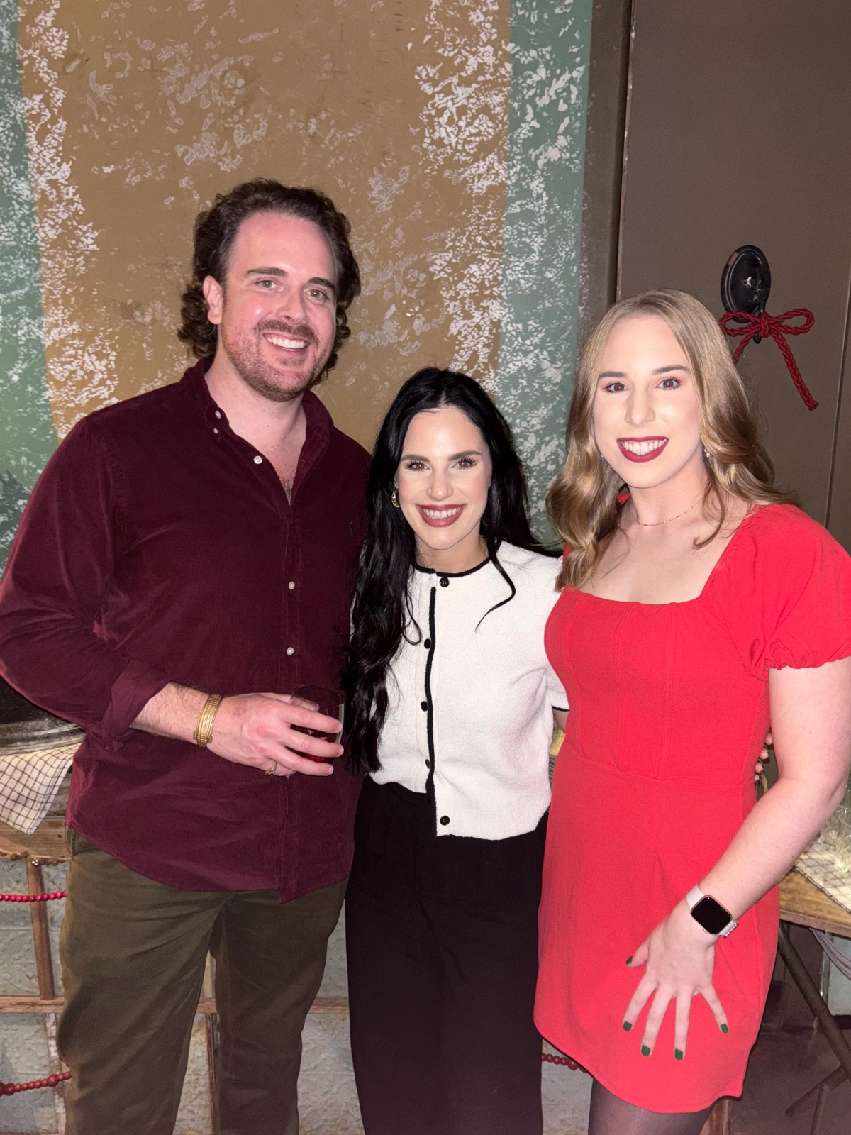 Three medical team members posing together in holiday outfits