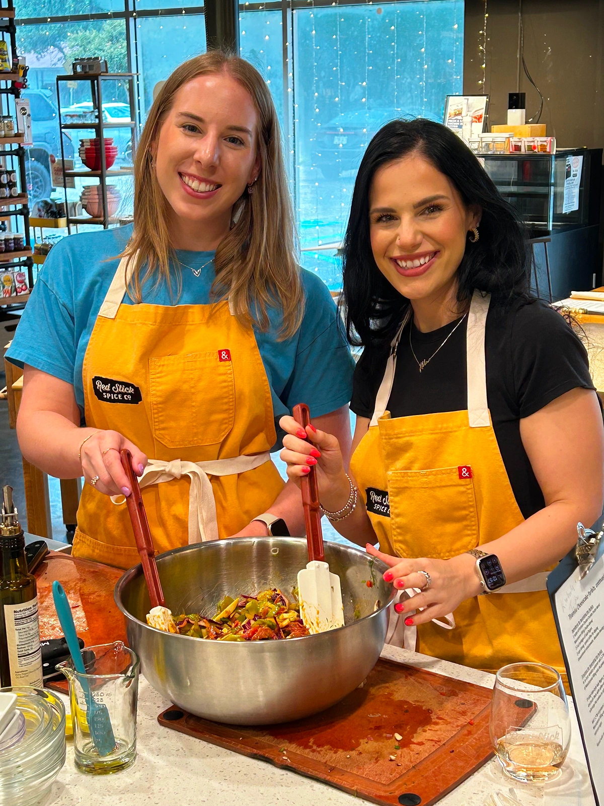 Two team members preparing food together in a kitchen
