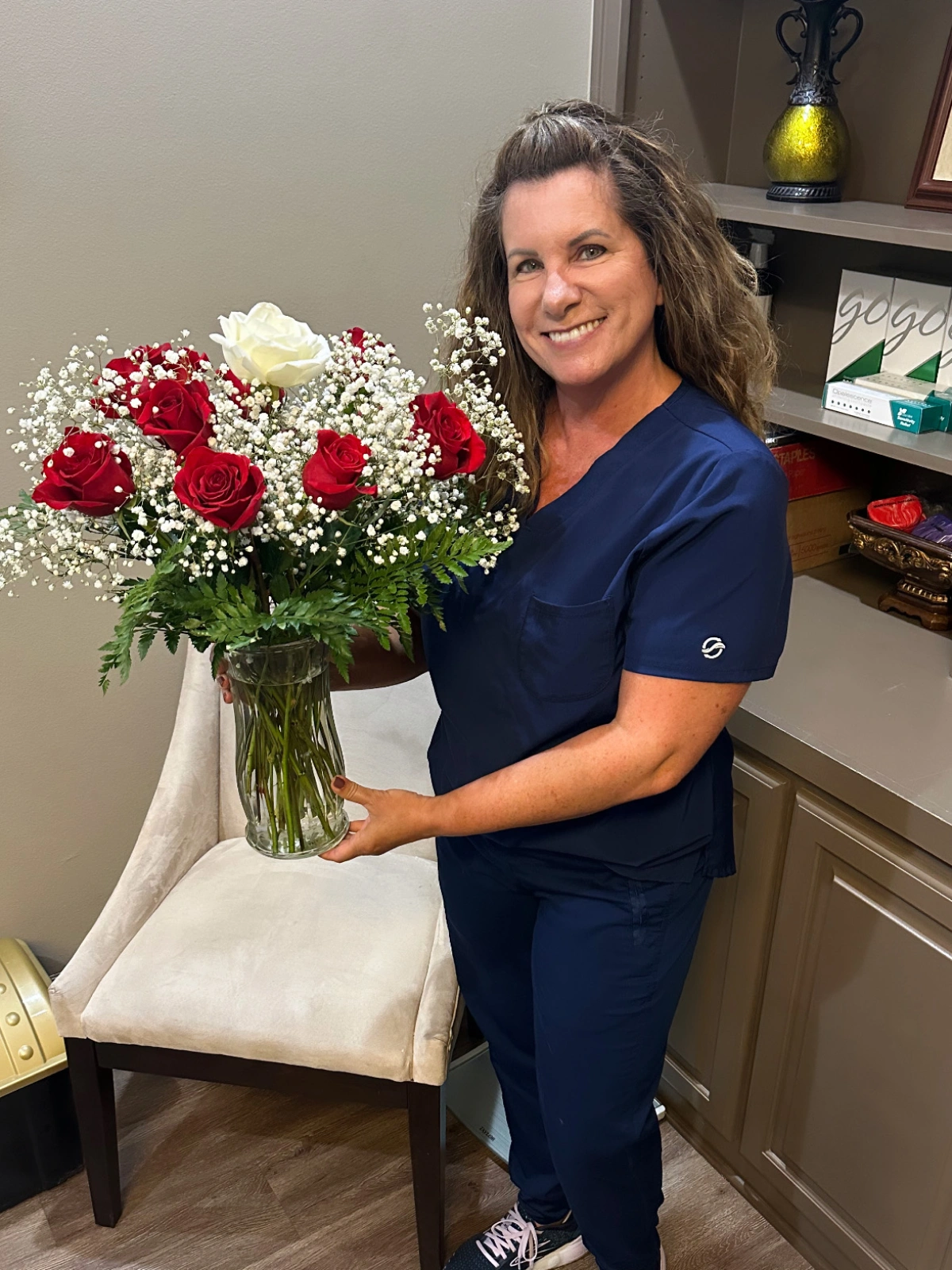 A staff member holding a bouquet of flowers