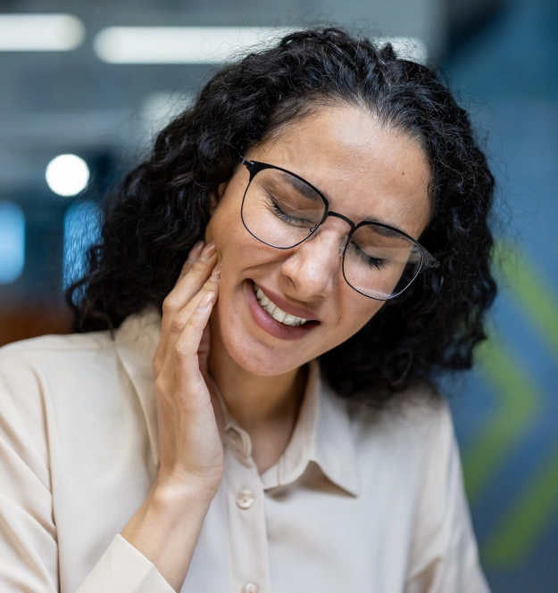 Woman receiving dental care while experiencing symptoms related to teeth grinding