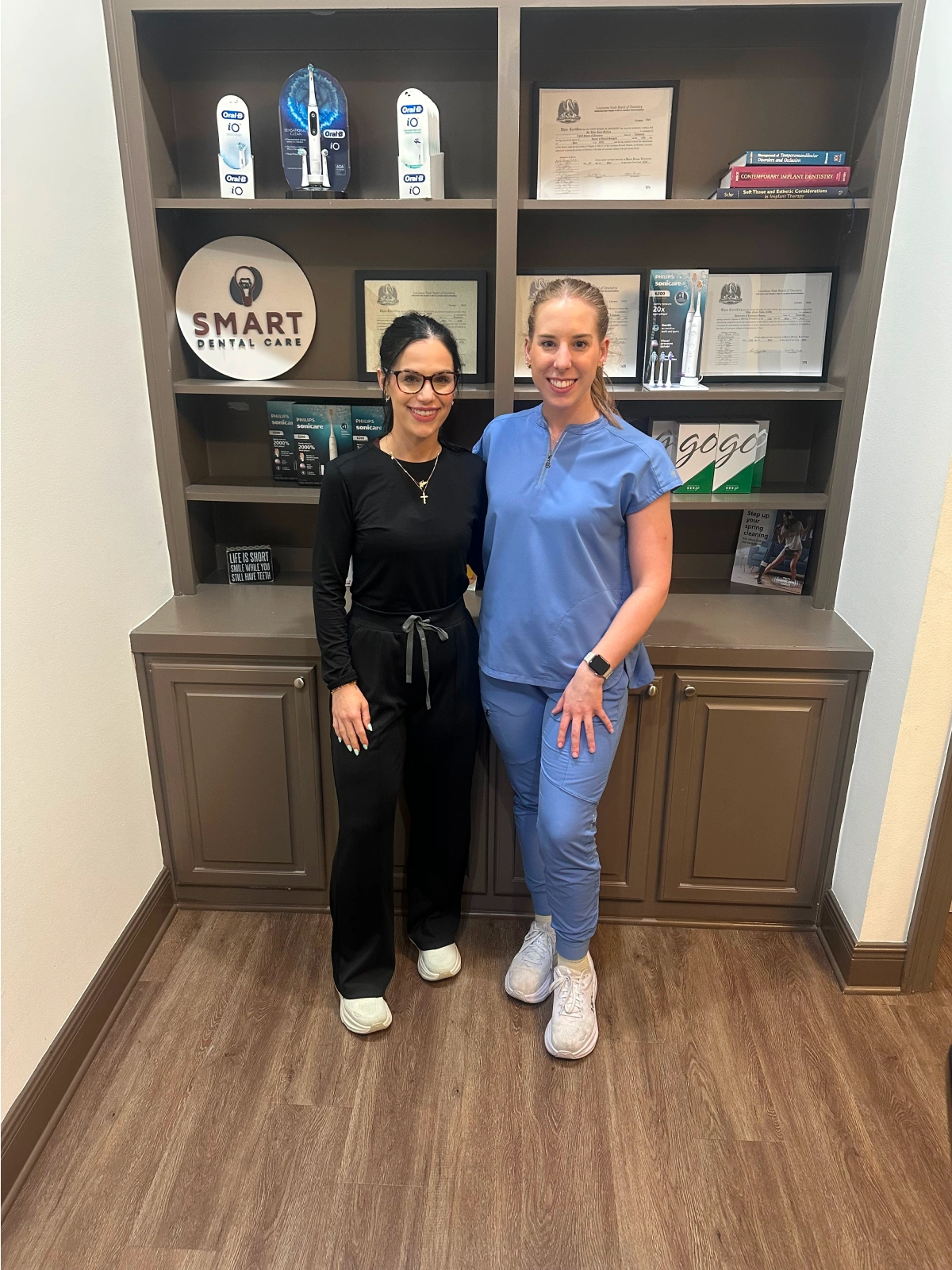 Two team members standing together and smiling in an office