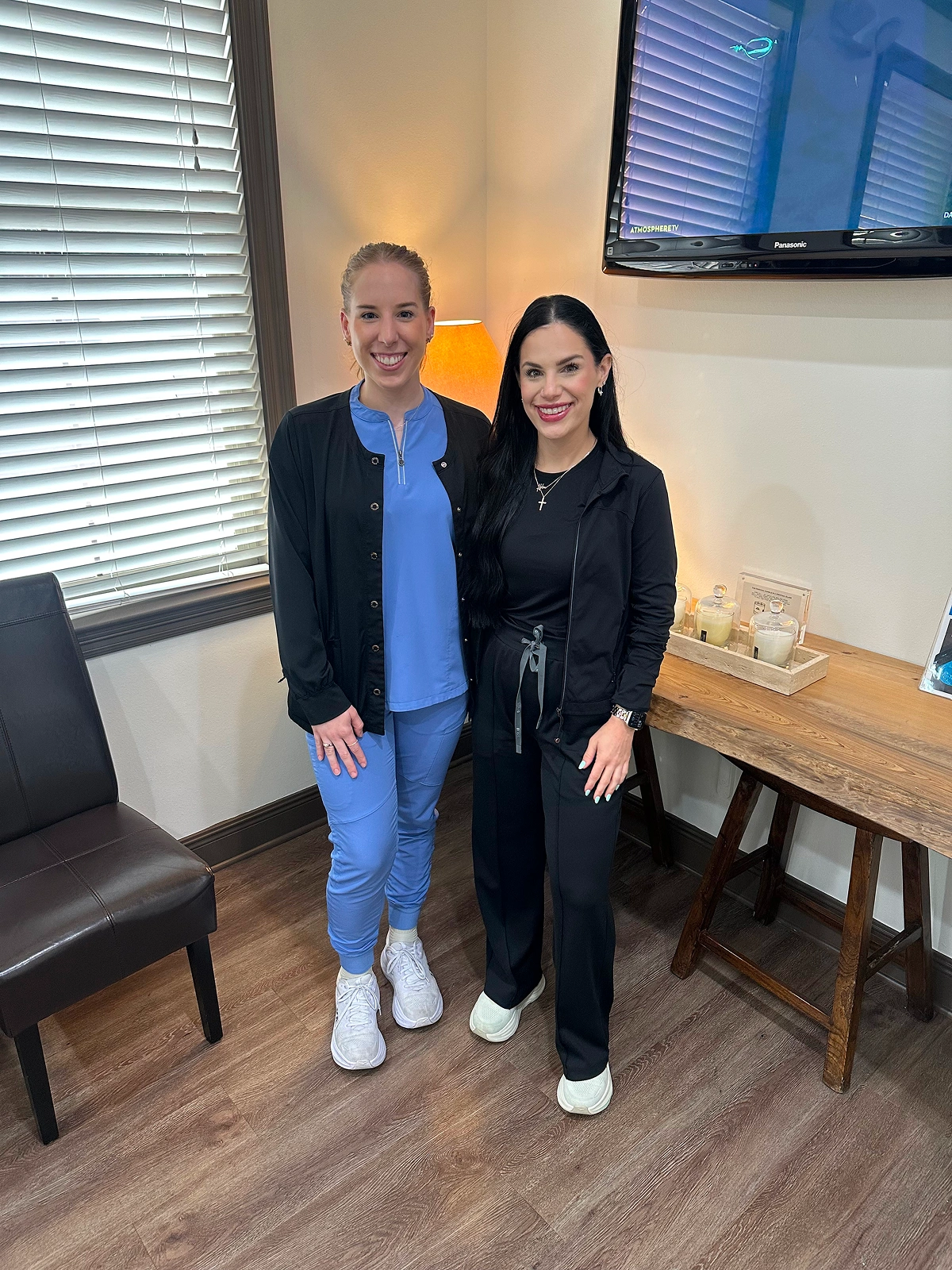 Two team members posing together in an office