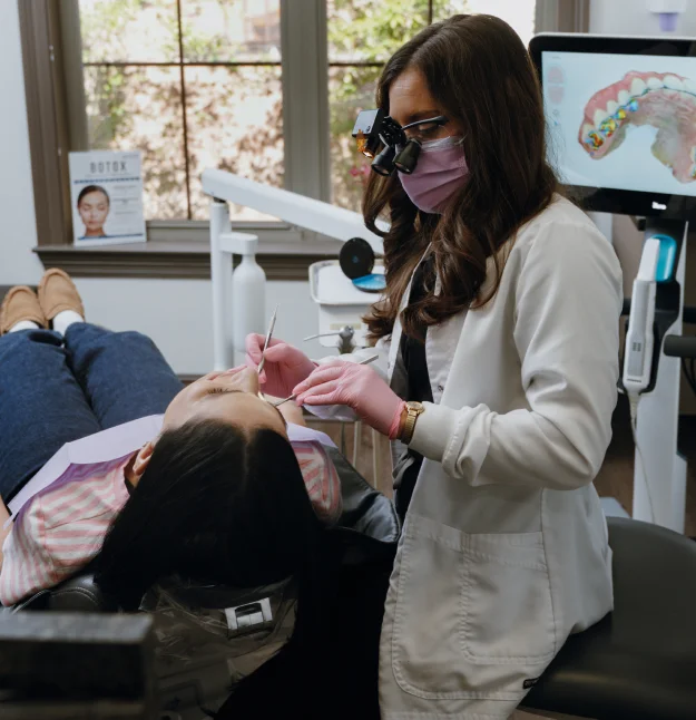 A dentist examining and treating a patient’s gums in a dental clinic