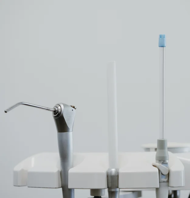 Dental tooth extraction equipment with a handpiece and suction tools mounted on a dental unit